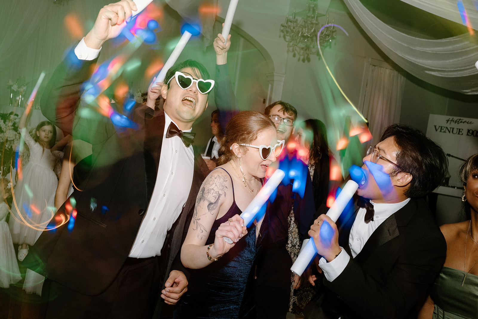 Guests celebrating with glow sticks and party glasses