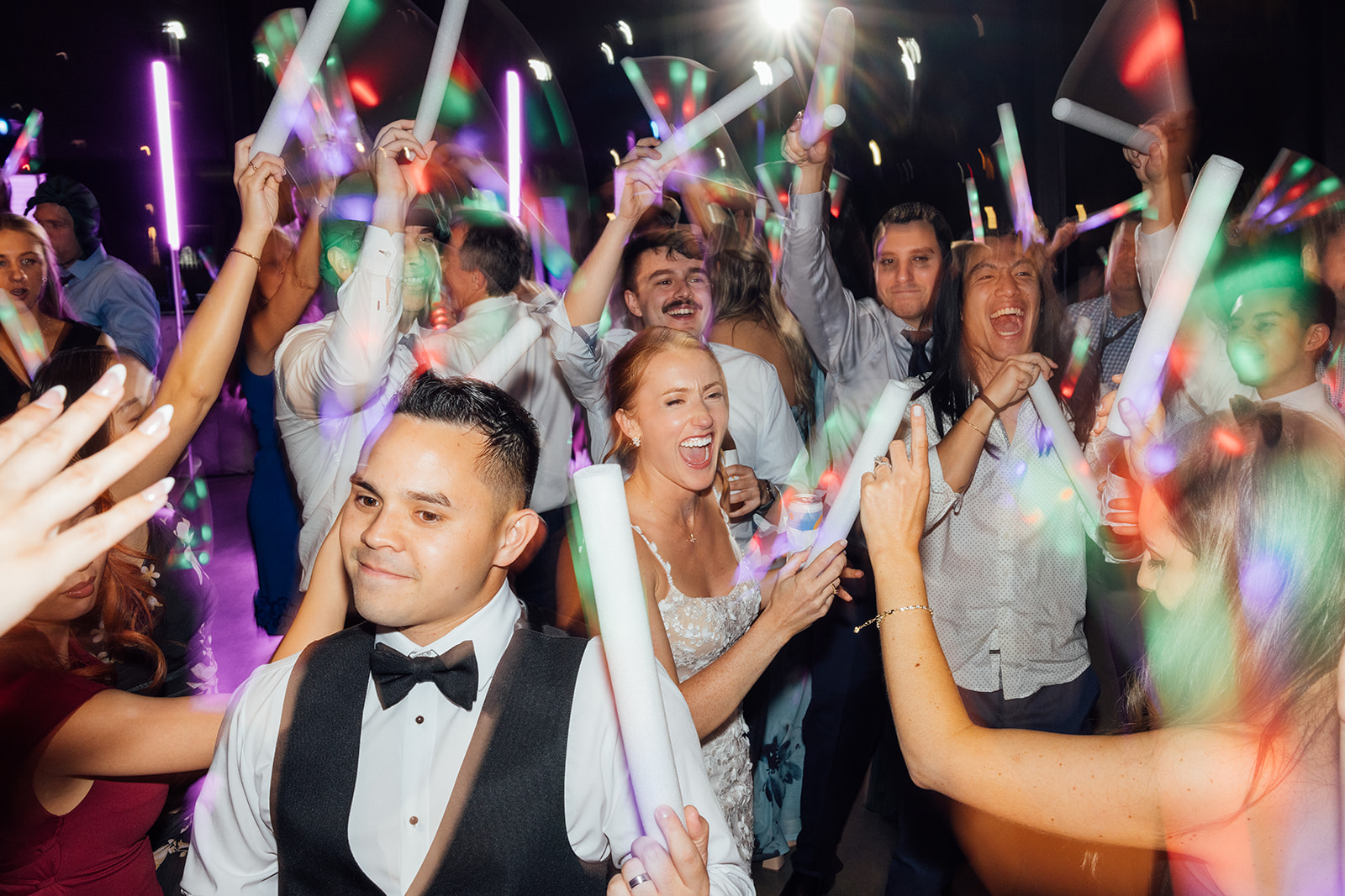 Guests raising glow sticks during a high-energy reception set